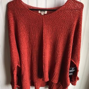 Slip on this rust color sweater to keep you cozy